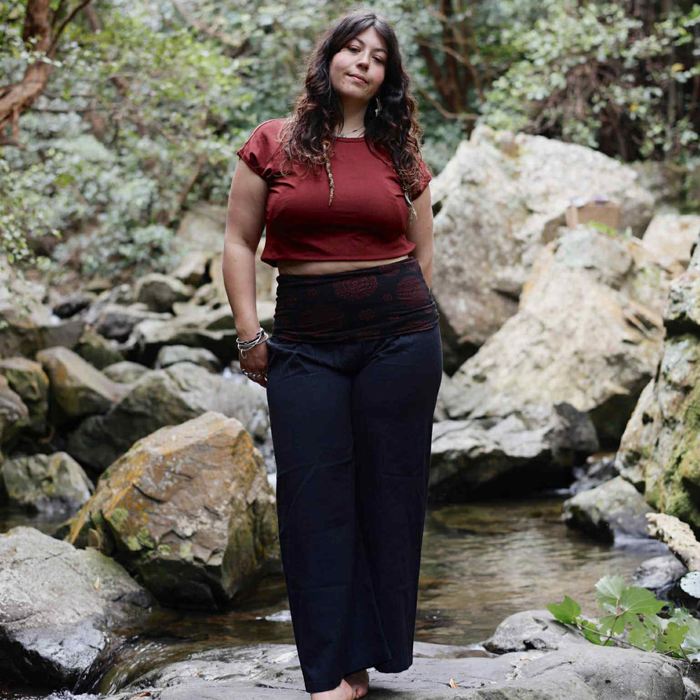 
                  
                    Load image into Gallery viewer, Woman standing in a forest with rocks and trees in the background
                  
                