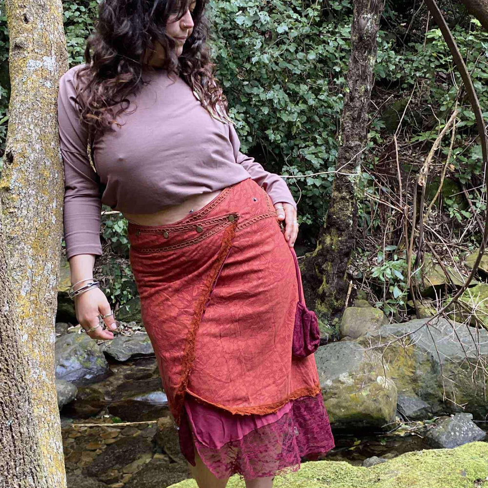 
                  
                    Load image into Gallery viewer, Woman in a pink top and red skirt standing in a forest setting
                  
                