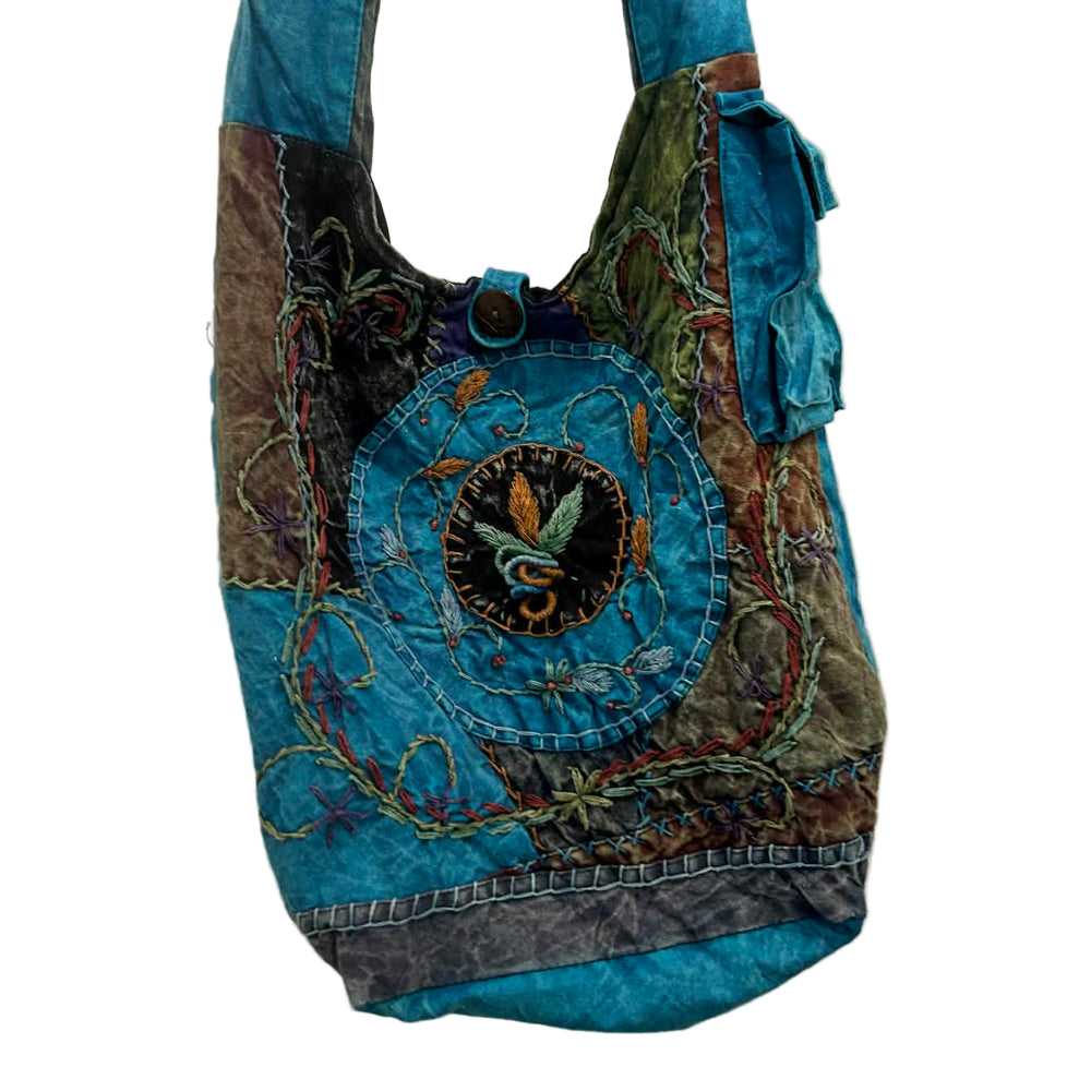 Blue and multicolored handbag with decorative patterns on a white background